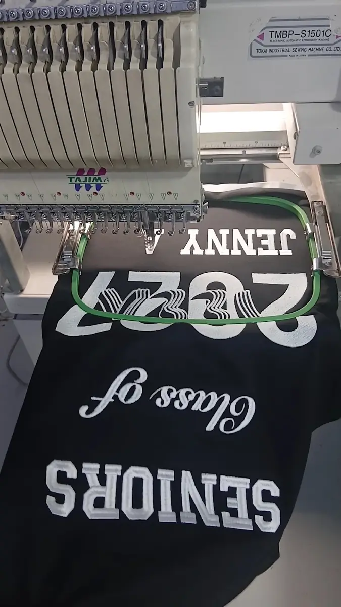 Embroidery machine stitching names onto a garment