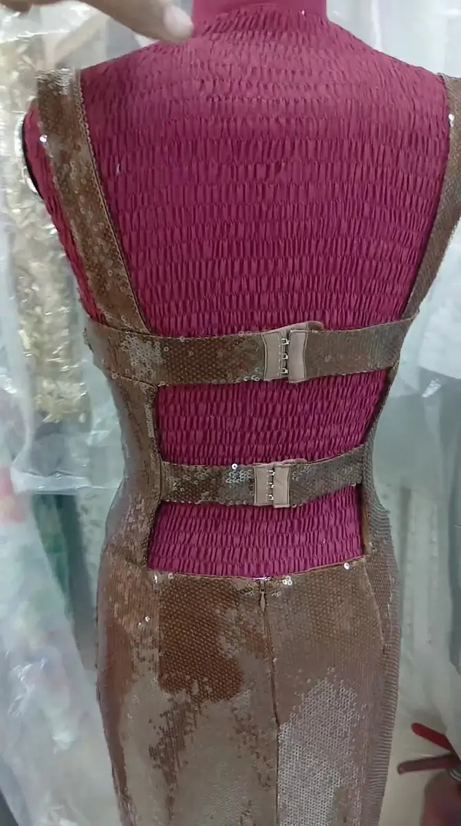 A dress on the work bench with its back seam being fitted